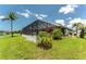 Exterior home view featuring a screened in pool, landscaping, and a backyard with water access at 167 & 169 Marker Rd, Rotonda West, FL 33947
