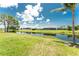Scenic backyard view featuring lush green grass, a tranquil canal, and the peaceful neighborhood at 167 & 169 Marker Rd, Rotonda West, FL 33947