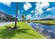 Water view from backyard featuring a tropical palm tree, lawn, and screened in lanai at 167 & 169 Marker Rd, Rotonda West, FL 33947