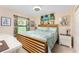 Bedroom with bed, large window, a beach themed wall hanging, and end tables at 167 & 169 Marker Rd, Rotonda West, FL 33947