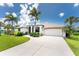 Charming single-story home with a well-manicured lawn, tropical landscaping, and a circular driveway at 167 & 169 Marker Rd, Rotonda West, FL 33947