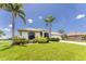 Charming single-story home with a well-manicured lawn, tropical landscaping, and a circular driveway at 167 & 169 Marker Rd, Rotonda West, FL 33947