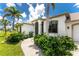Close-up of front entrance with manicured landscaping, arched entryway, and well-maintained lawn at 167 & 169 Marker Rd, Rotonda West, FL 33947