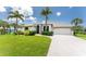 Charming single-story home with a well-manicured lawn, tropical landscaping, and a circular driveway at 167 & 169 Marker Rd, Rotonda West, FL 33947