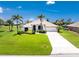 Charming single-story home featuring lush lawn, palm trees and a pristine driveway at 167 & 169 Marker Rd, Rotonda West, FL 33947