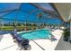 Inviting screened-in pool and patio area with clear blue water, lounge chairs, and peaceful backyard canal views at 167 & 169 Marker Rd, Rotonda West, FL 33947