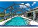 Sparkling screened-in pool and patio with lounge chairs and backyard canal views in a beautiful outdoor space at 167 & 169 Marker Rd, Rotonda West, FL 33947