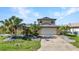 Two-story home with a spacious driveway, two-car garage, and lush landscaping at 18566 Arapahoe Cir, Port Charlotte, FL 33948