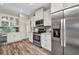 Bright kitchen with stainless steel appliances, wood floor and white cabinets at 18566 Arapahoe Cir, Port Charlotte, FL 33948