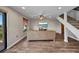 Open living room with wood flooring, ceiling fan, and TV, complemented by a staircase at 18566 Arapahoe Cir, Port Charlotte, FL 33948