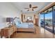 Bright bedroom featuring a ceiling fan, wood floors and access to private patio at 18566 Arapahoe Cir, Port Charlotte, FL 33948