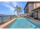 Outdoor pool with water view and a large palm tree for shade on a sunny day at 18566 Arapahoe Cir, Port Charlotte, FL 33948