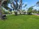 Lush green backyard featuring well-maintained lawn, scattered trees, and verdant landscaping at 2131 Heasley Rd, Englewood, FL 34223