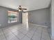 An empty bedroom has tile flooring, a window, a ceiling fan, and plenty of natural light at 2131 Heasley Rd, Englewood, FL 34223
