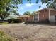 Exterior of the house features a manicured yard, gravel driveway, orange stucco, and attached garage at 2131 Heasley Rd, Englewood, FL 34223