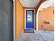 The front door is bright blue with decorative glass surrounded by stucco walls and a porch light at 2131 Heasley Rd, Englewood, FL 34223