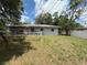 View of the home's exterior from backyard with a grassy area and fenced perimeter for privacy at 2174 Schwalbe Way, Sarasota, FL 34235