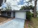 A single story home with a driveway and a one car garage and a light blue painted exterior at 2174 Schwalbe Way, Sarasota, FL 34235