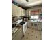 A compact kitchen with all-white cabinets and appliances, and decorative countertops at 2174 Schwalbe Way, Sarasota, FL 34235