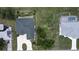 Overhead view of a home with a dark roof, lush landscaping, and a circular driveway at 2244 Mauritania Rd, Punta Gorda, FL 33983