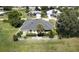 Aerial view of a landscaped home with a fenced yard, palm trees, and a circular driveway at 2244 Mauritania Rd, Punta Gorda, FL 33983