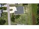 Birds-eye view of a home with a dark roof and circular driveway situated on a spacious lot at 2244 Mauritania Rd, Punta Gorda, FL 33983