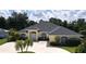 Charming, light yellow single-story home with a well-manicured lawn and mature palm trees in the front yard at 2244 Mauritania Rd, Punta Gorda, FL 33983
