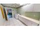 Clean laundry room with white tile, cabinets, and sink for convenience at 2244 Mauritania Rd, Punta Gorda, FL 33983