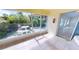 Relaxing tiled sunroom featuring a white stone table, lush landscaping, and access to backyard at 2244 Mauritania Rd, Punta Gorda, FL 33983