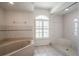 Relaxing bathroom featuring a soaking tub, walk-in shower, and window with plantation shutters at 23101 Hillsdale Ave, Port Charlotte, FL 33954