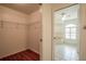 Walk-in closet attached to a bathroom featuring a tub and window with plantation shutters at 23101 Hillsdale Ave, Port Charlotte, FL 33954