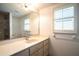 Bright bathroom featuring a single sink vanity, a large mirror, and a window at 23101 Hillsdale Ave, Port Charlotte, FL 33954