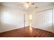 Bright bedroom featuring hardwood floors, ceiling fan, and double door closet at 23101 Hillsdale Ave, Port Charlotte, FL 33954