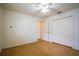A neutral bedroom with ceiling fan, double door closet, and wood floors at 23101 Hillsdale Ave, Port Charlotte, FL 33954