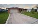 Charming home featuring a long concrete driveway, attached garage, and a well-manicured lawn at 23101 Hillsdale Ave, Port Charlotte, FL 33954