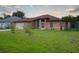 Tan single-story home featuring arched windows and a well-maintained front lawn at 23101 Hillsdale Ave, Port Charlotte, FL 33954
