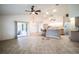 Open-concept living room with tile floors, ceiling fans, and a partial view of the kitchen at 23101 Hillsdale Ave, Port Charlotte, FL 33954