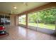 Large sunroom with tile floors, ceiling fans, and sliding door access to the lush backyard at 23101 Hillsdale Ave, Port Charlotte, FL 33954