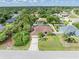 Aerial view of a single-story home with a well-manicured lawn, mature landscaping, and a screened-in pool at 2373 Chartwell Ave, North Port, FL 34288