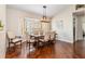 Inviting dining room features wood floors, large window with blinds, and a modern rustic chandelier at 2373 Chartwell Ave, North Port, FL 34288