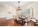 Bright dining room with wood floors, a square wood dining table, and updated lighting at 2373 Chartwell Ave, North Port, FL 34288