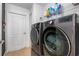 Modern laundry room with front loading washer and dryer and ample shelving space at 2373 Chartwell Ave, North Port, FL 34288