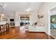 Open-concept living room with hardwood floors, a comfortable sectional sofa, and a sliding glass door to the pool area at 2373 Chartwell Ave, North Port, FL 34288