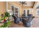 Inviting covered patio featuring brick flooring, ceiling fan, and comfortable seating around a fire pit at 2373 Chartwell Ave, North Port, FL 34288