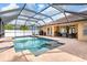 Inviting screened-in pool area with a sparkling pool, brick patio, and peaceful outdoor space at 2373 Chartwell Ave, North Port, FL 34288