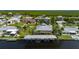 Aerial view of waterfront home featuring a metal roof and private boat dock with scenic views of the surrounding landscape at 24261 Captain Kidd Blvd, Punta Gorda, FL 33955