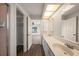 Bathroom showcasing a double sink vanity, a lighted mirror, and access to the closet enhance daily routines at 24261 Captain Kidd Blvd, Punta Gorda, FL 33955