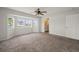 Bright bedroom featuring plush carpeting, ceiling fan and a bay window with natural light and en suite bathroom at 24261 Captain Kidd Blvd, Punta Gorda, FL 33955