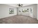 Comfortable bedroom featuring plush carpeting, a ceiling fan, and a bay window with natural light and a view of the neighborhood at 24261 Captain Kidd Blvd, Punta Gorda, FL 33955