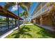 Backyard featuring well-maintained lawn, lush landscaping, canal views, and a private boat dock for waterfront enjoyment at 24261 Captain Kidd Blvd, Punta Gorda, FL 33955